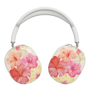 以下が含まれることがあります： 白いオーバーイヤーヘッドホン、フローラルデザイン。 イヤーカップは、ピンク、赤、黄色の水彩ハイビスカスの花が描かれたクリーム色の背景です。 ヘッドバンドは白です。