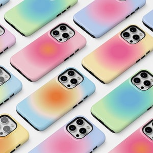 Puede incluir: Una colección de fundas de teléfono coloridas con un diseño degradado. Las fundas están dispuestas en una cuadrícula y presentan una variedad de colores, incluyendo rosa, azul, amarillo y verde.