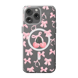 May include: A clear phone case with a gray background and a pattern of pink bows and cherries. The case has a built-in ring holder with a white background and a cherry design.