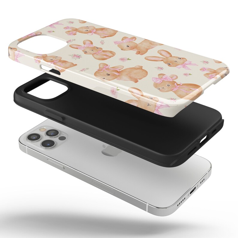May include: A clear phone case with a design of pink-bowed bunnies on a cream background. The case is shown in three parts: the printed design, a black protective layer, and a silver phone.