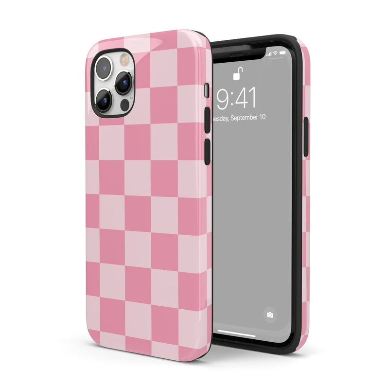 May include: A pink and white checkered phone case for an iPhone. The case has a raised camera bump and a clear back panel. The phone case is shown with a black phone inside.