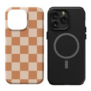 May include: Two phone cases, one with a black and white chequered pattern and the other with a black case and a silver ring on the back.