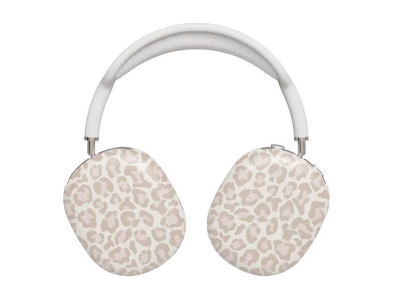 May include: White wireless headphones with a leopard print design. The headphones have a white headband and large earcups.