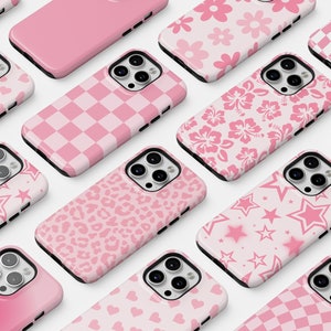 May include: A collection of pink iPhone cases with various patterns, including hearts, stars, flowers, and checkered designs.