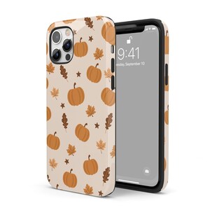 Puede incluir: Una funda para iPhone beige con un patr&oacute;n de calabazas naranjas y hojas marrones. La funda tiene una parte posterior transparente y un borde negro. La pantalla del tel&eacute;fono muestra la hora 9:41 y la fecha mi&eacute;rcoles 10 de septiembre.