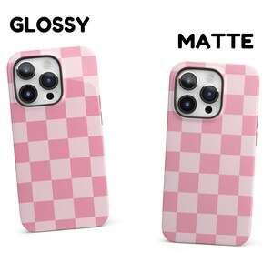 May include: Two iPhone cases with a pink and white checkered pattern. The case on the left is glossy and the case on the right is matte.