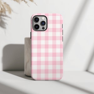 May include: A pink and white gingham phone case for an iPhone.
