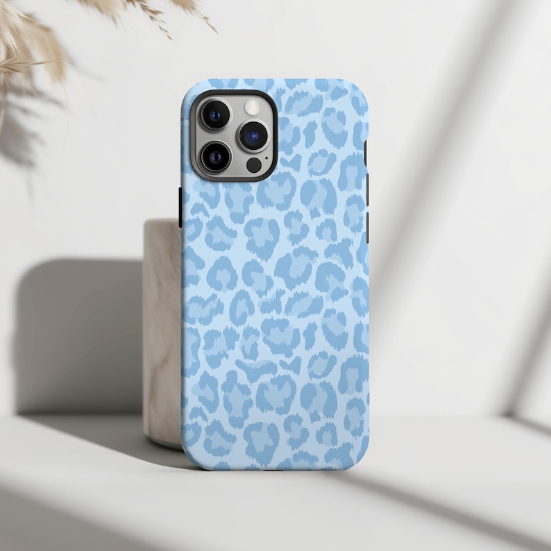 Pu&ograve; includere: Una custodia per telefono blu chiaro con un motivo a stampa leopardata.