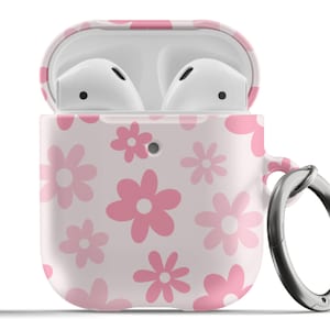 Puede incluir: Una funda de color rosa y blanco con estampado floral para Apple AirPods con un anillo de metal plateado.