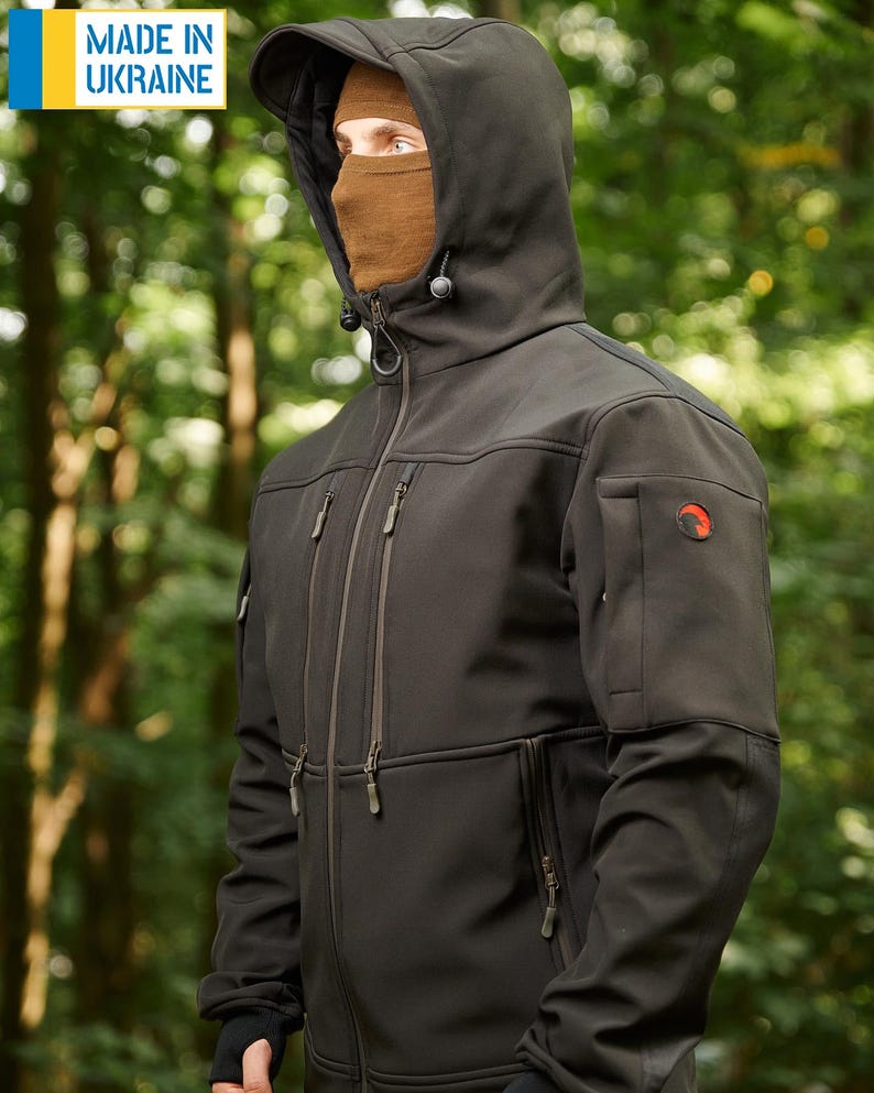 May include: A black softshell jacket with a zipper closure, multiple pockets, and a hood. The jacket has a logo on the right sleeve. The text "MADE IN UKRAINE" is visible in the top left corner of the image.