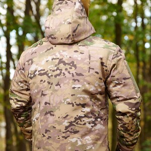 May include: A camouflage jacket with a hood. The jacket is made of a soft, water-resistant material and has a zipper closure. The jacket is perfect for outdoor activities.