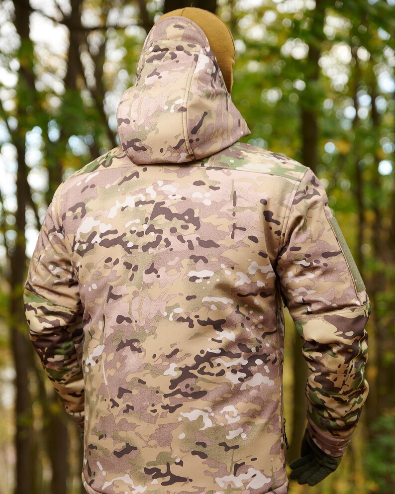 May include: A camouflage jacket with a hood. The jacket is made of a soft, water-resistant material and has a zipper closure. The jacket is perfect for outdoor activities.