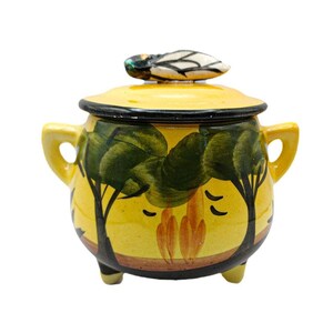 May include: A yellow ceramic lidded jar with two side handles and three small feet. The exterior features a hand-painted landscape with green trees and orange flames against a yellow background. A sculpted insect figure sits on the lid.