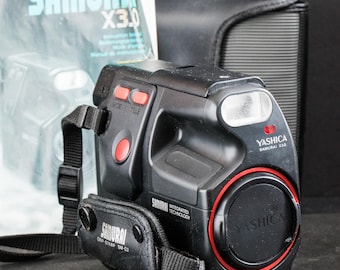 Yashica Samurai X3.0, una cámara de película de 35 mm de medio formato con estuche y manual.