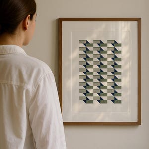May include: A framed print featuring a geometric design in green, grey, and navy. The artwork is presented in a wooden frame with a white mount. The print is displayed on a light-coloured wall.