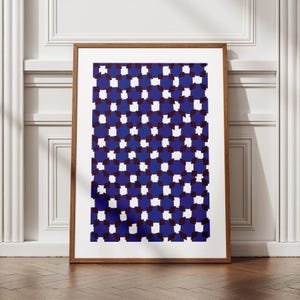 Könnte beinhalten: Ein gerahmter Druck mit einem geometrischen Muster aus abwechselnd weißen und blauen Quadraten. Die Quadrate sind versetzt angeordnet, wodurch ein Gefühl von Tiefe und Bewegung entsteht. Der Druck ist in einem einfachen Holzrahmen gerahmt.