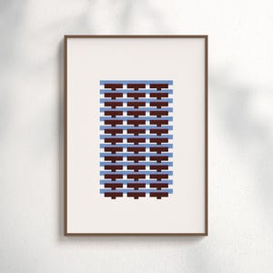 Op de afbeelding: Een ingelijste kunstdruk met een geometrisch ontwerp. Het kunstwerk toont een herhalend patroon van donkerbruine en lichtblauwe horizontale rechthoeken. De print is geplaatst tegen een crèmekleurige achtergrond en ingelijst in een bruine houten lijst.