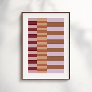 Puede incluir: Impresión artística abstracta enmarcada, con bandas verticales de color. Los bloques de color incluyen tonos de rojo, rosa, marrón y beige. La obra de arte se muestra en un marco marrón, adecuada para la decoración del hogar o la oficina.