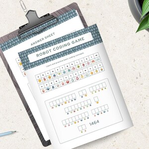 Pode incluir: Uma prancheta cont&eacute;m duas folhas de papel com o texto "ANSWER SHEET" e "ROBOT CODING GAME". O jogo ensina conceitos b&aacute;sicos de codifica&ccedil;&atilde;o com ilustra&ccedil;&otilde;es coloridas de rob&ocirc;s. Um copo de caf&eacute; gelado, l&aacute;pis e uma pulseira tamb&eacute;m s&atilde;o vis&iacute;veis.