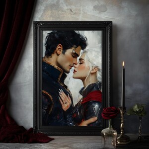 May include: A framed print depicts a romantic scene of a couple about to kiss. The man has dark hair and a navy blue jacket with gold accents. The woman has white hair and a red cape. A black candle and a red rose are in the foreground.