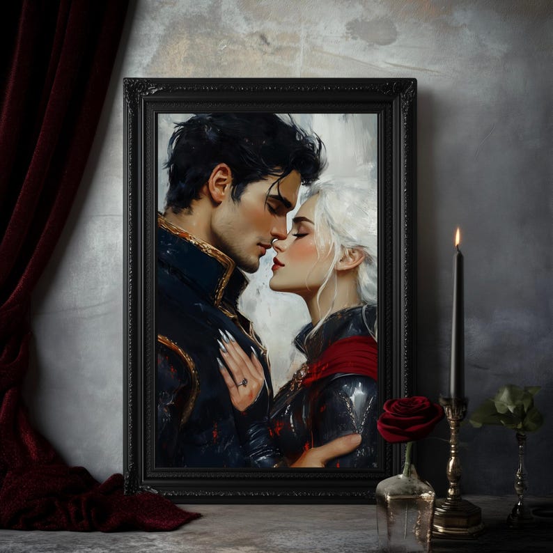 May include: A framed print depicts a romantic scene of a couple about to kiss. The man has dark hair and a navy blue jacket with gold accents. The woman has white hair and a red cape. A black candle and a red rose are in the foreground.