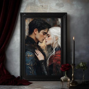 May include: A framed artwork depicts a romantic scene of a couple embracing. The man has dark hair and wears a blue and black jacket. The woman has white hair and a red cloak. The artwork is in a black frame, with a candle and rose in the foreground.
