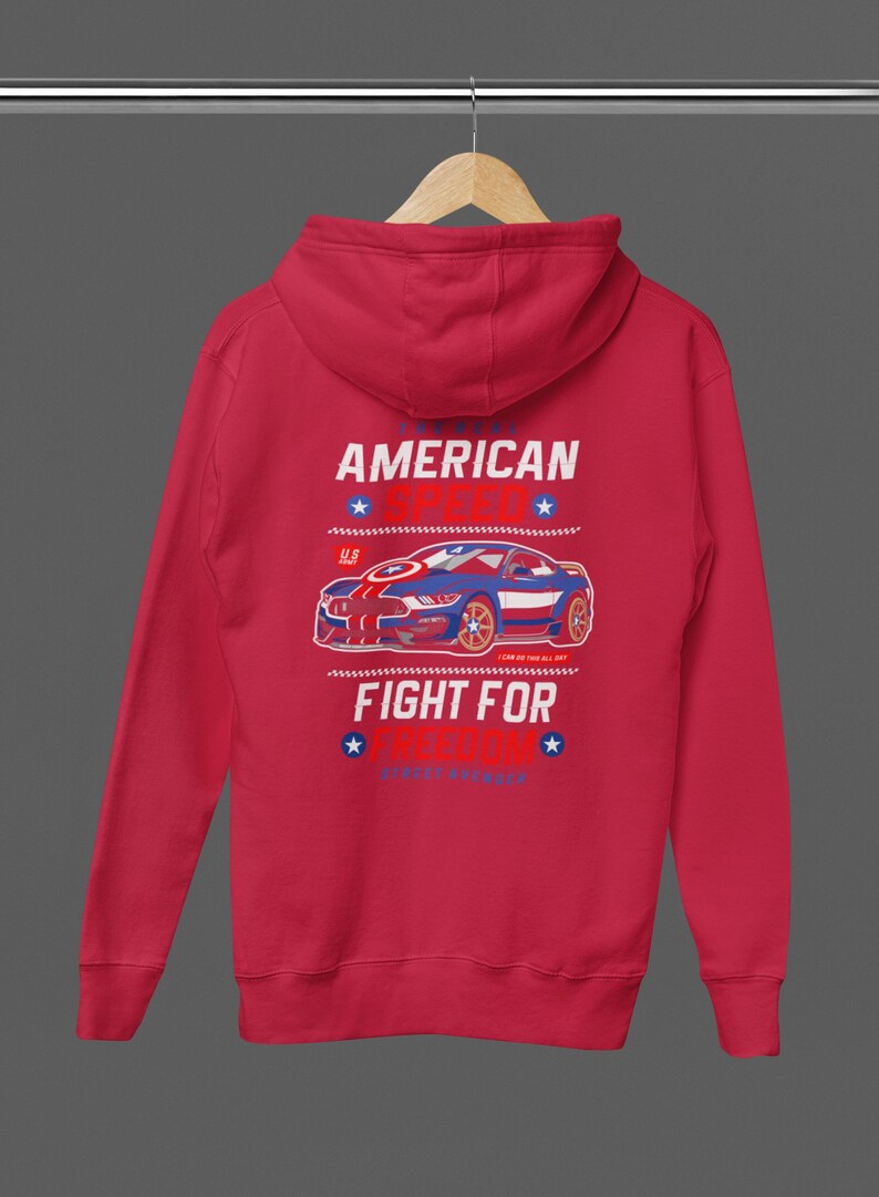 Op de afbeelding: Rode hoodie met een afbeelding van een blauwe en rode sportwagen. De tekst op de achterkant luidt "AMERICAN SPEED" en "FIGHT FOR FREEDOM". Het ontwerp bevat sterren en strepen.