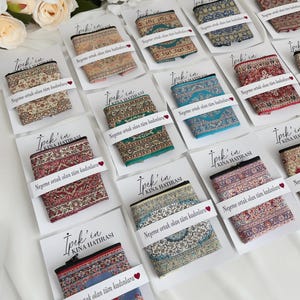 May include: A collection of small fabric pouches with patterned designs, displayed on white cards. The pouches showcase a variety of colours, including red, blue, and green. Text in Turkish is printed on the cards.