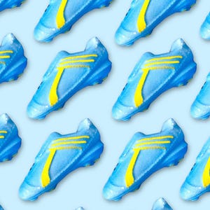 Può includere: Motivo ripetuto di scarpe da calcio blu e gialle su sfondo azzurro. Le scarpe hanno una base blu con strisce gialle e un design a forma di T giallo. Disposte a griglia.
