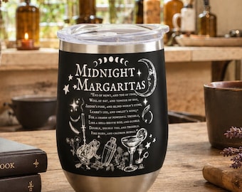 May include: A black stainless steel tumbler with a clear lid, featuring white printed text that reads Midnight Margaritas, along with illustrations of a cocktail glass, a shaker, a frog, and moon phases, set against a dark background.