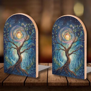 May include: Two wooden bookends with a painted fantasy scene. Each bookend features a tree with a swirling galaxy background in shades of blue, green, and yellow. The bookends have a natural wood edge and a metal base.