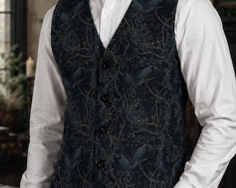 Pode incluir: Um colete azul-escuro com um padrão detalhado de pássaros pousados em ramos com detalhes em tom dourado. O colete tem um decote em V, quatro botões pretos e é usado sobre uma camisa branca de manga comprida com calças cinzentas escuras.