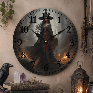 May include: A round wall clock featuring a dark, atmospheric illustration of a figure in a black cloak and pointed hat standing in a misty forest. The clock face has black Arabic numerals, black hour and minute hands, and a thin red second hand.