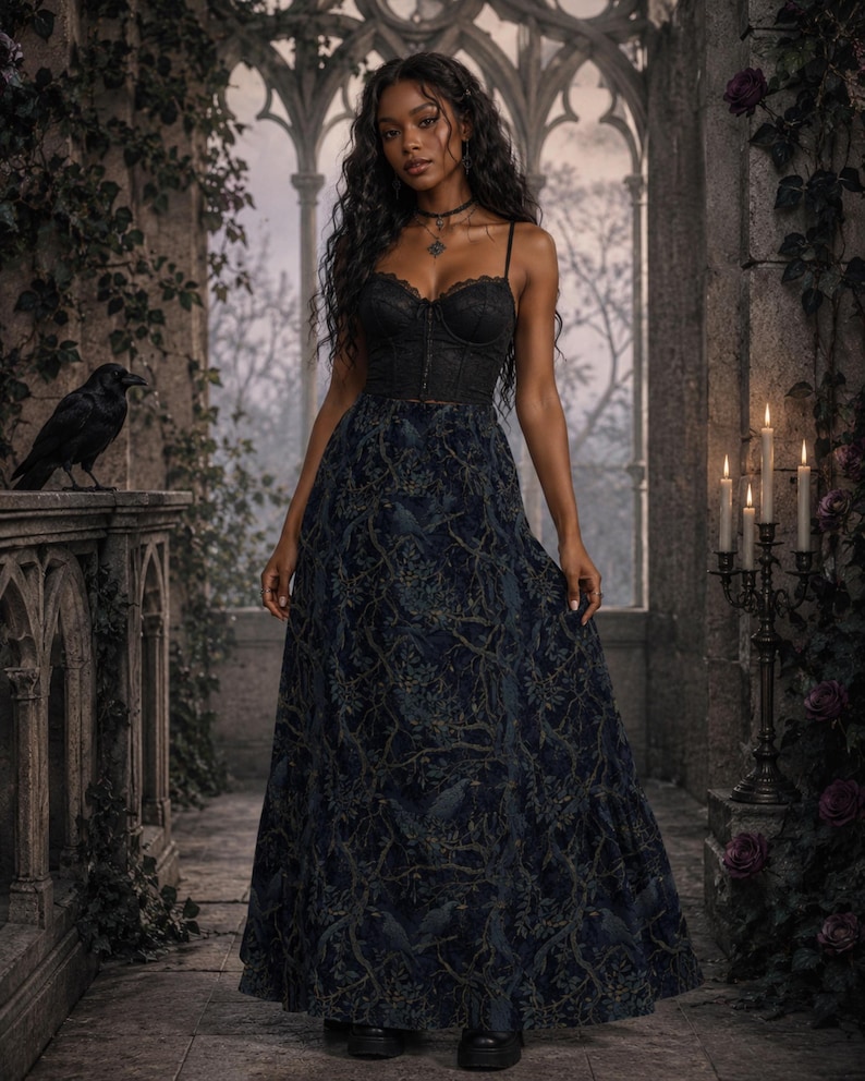 May include: A black lace corset top with thin straps paired with a floor-length, dark navy blue skirt featuring a repeating pattern of branches and birds. The ensemble is completed with black platform shoes and a simple black choker necklace.