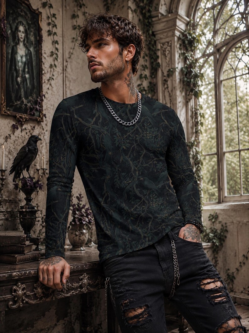 Pode incluir: Uma camisola de manga comprida e gola redonda num tom verde floresta escuro, com um padr&atilde;o tonal intrincado de ramos entrela&ccedil;ados, folhas e p&aacute;ssaros escondidos. A pe&ccedil;a &eacute; combinada com cal&ccedil;as de ganga pretas desgastadas com rasgos nos joelhos.