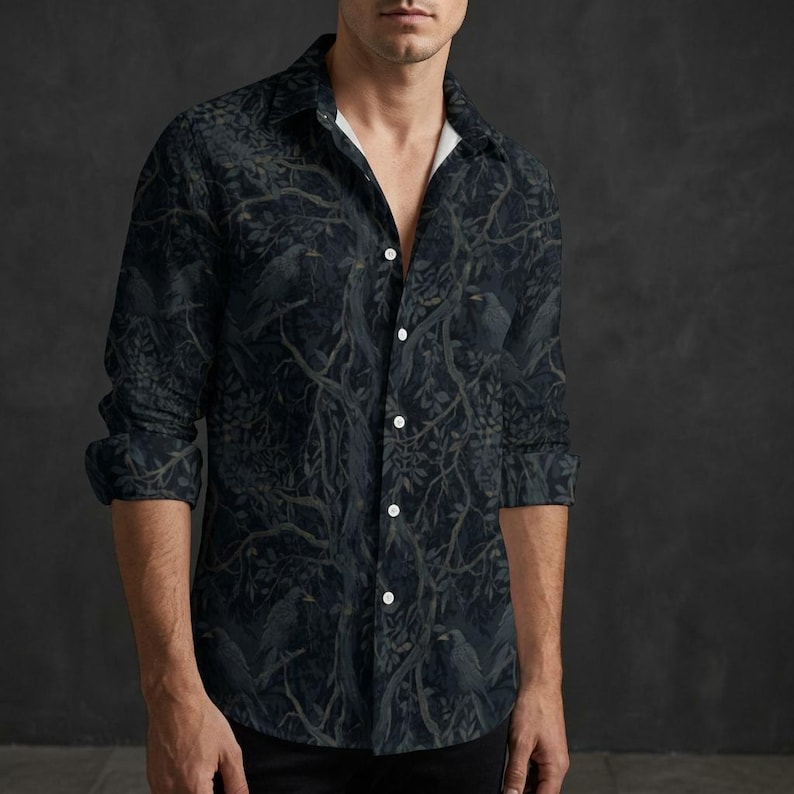 May include: A long-sleeve button-down shirt featuring a dark, moody forest pattern with silhouettes of birds perched on branches. The shirt has a classic collar, a white inner placket, and a repeating print of trees and foliage in shades of black and gray.