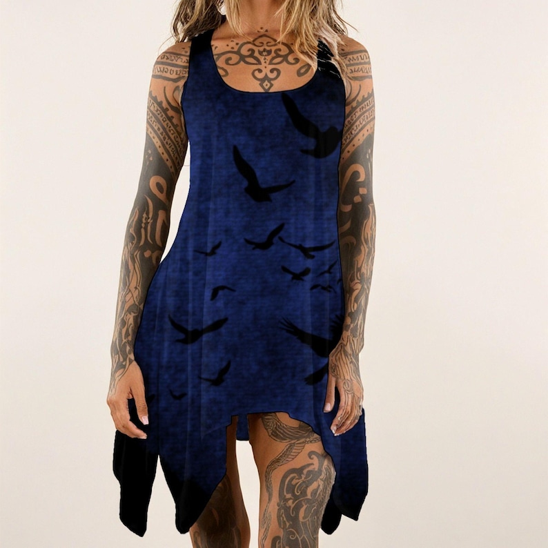 May include: A sleeveless, dark blue dress with a flowing, asymmetrical hemline. The dress features a pattern of black birds in flight across the front. The fabric has a textured appearance, and the dress has a scoop neckline.