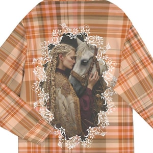 May include: A hooded sweatshirt with a plaid pattern in shades of orange and brown. The front of the sweatshirt features a white floral design with a woman and a white horse.