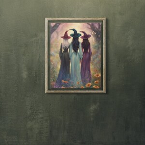 May include: A framed wall art print depicting three figures standing with their backs to the viewer, wearing long dresses and pointed hats in shades of red, teal, and purple. They are positioned in a forest clearing filled with colorful flowers.