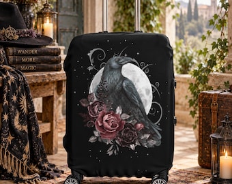 Può includere: Una copertura per valigia nera con una stampa grafica di un corvo appollaiato davanti a una luna piena, circondato da rose rosso scuro e motivi in filigrana. La copertura è dotata di manico estraibile e quattro ruote alla base.