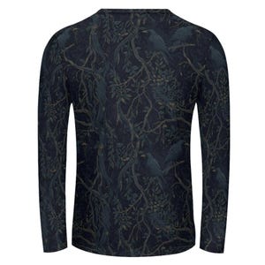 Pode incluir: Uma camisa de manga comprida em azul marinho escuro com uma estampa integral de corvos pretos pousados em galhos de &aacute;rvores emaranhados e sem folhas com folhagem verde escura. A pe&ccedil;a tem gola redonda e bainha reta na parte inferior.