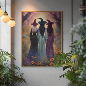 May include: A framed wall art print depicting three figures viewed from behind, each wearing a pointed hat in red, teal, or purple, and long flowing dresses in black, light blue, and purple, standing in a vibrant, colorful floral forest.
