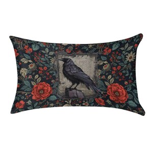 May include: A rectangular throw pillow featuring a central illustration of a black crow perched on an open book, framed by a vintage-style parchment background. The surrounding pattern consists of deep red flowers and green foliage on black.
