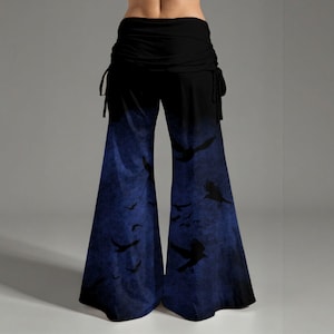 May include: Wide-leg pants featuring a solid black waistband with side drawstrings and a gradient pattern transitioning from black to a deep blue, decorated with a repeating silhouette print of flying birds across the lower legs.
