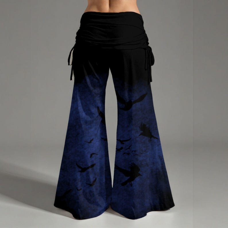 May include: Wide-leg pants featuring a solid black waistband with side drawstrings and a gradient pattern transitioning from black to a deep blue, decorated with a repeating silhouette print of flying birds across the lower legs.