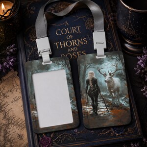 Puede incluir: Un portatarjetas vertical con un cord&oacute;n gris y clips de pl&aacute;stico blanco. Un lado presenta una ventana rectangular para una tarjeta de identificaci&oacute;n, mientras que el otro lado muestra una ilustraci&oacute;n de fantas&iacute;a de una persona junto a un ciervo.