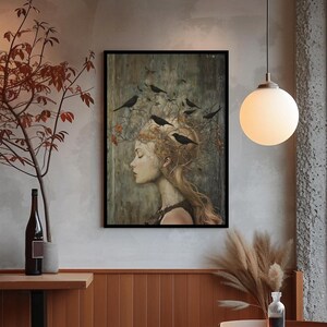 May include: A framed wall art print featuring a profile portrait of a person with long hair intertwined with bare branches and several black birds. The artwork uses a muted color palette of earthy browns, grays, and soft highlights on the face.
