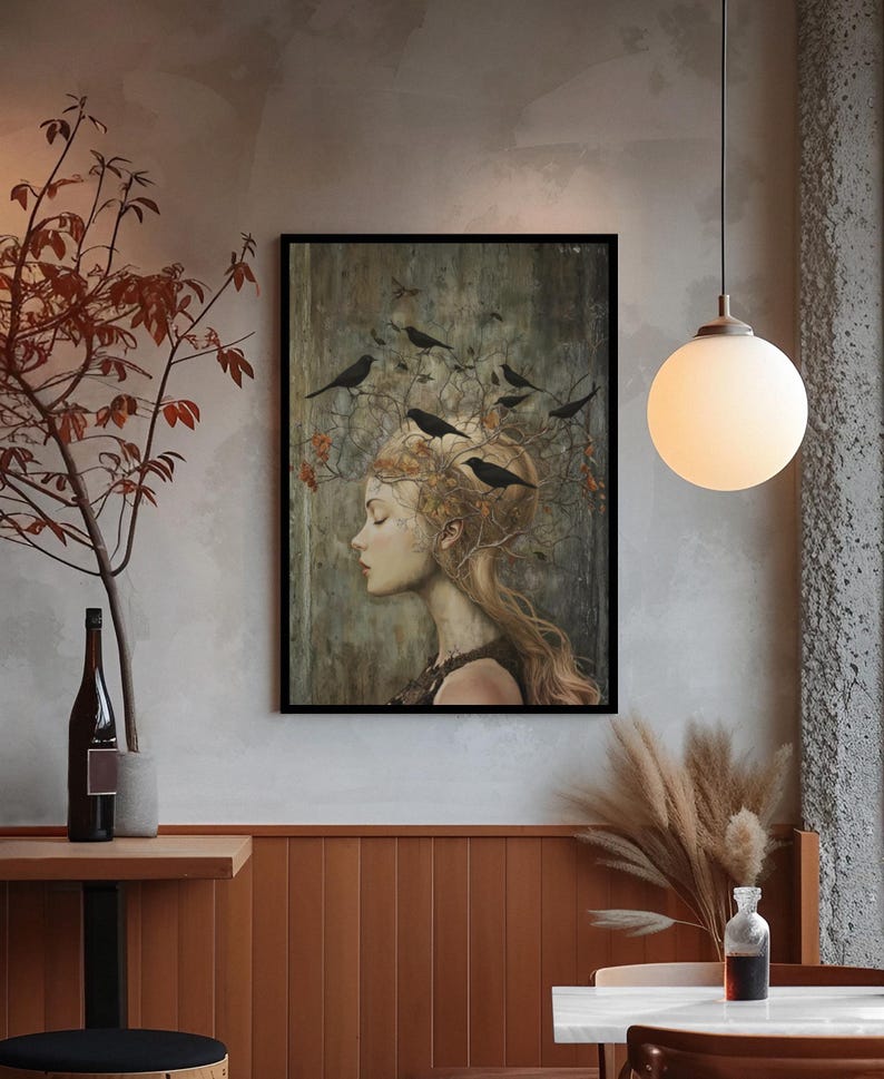May include: A framed wall art print featuring a profile portrait of a person with long hair intertwined with bare branches and several black birds. The artwork uses a muted color palette of earthy browns, grays, and soft highlights on the face.