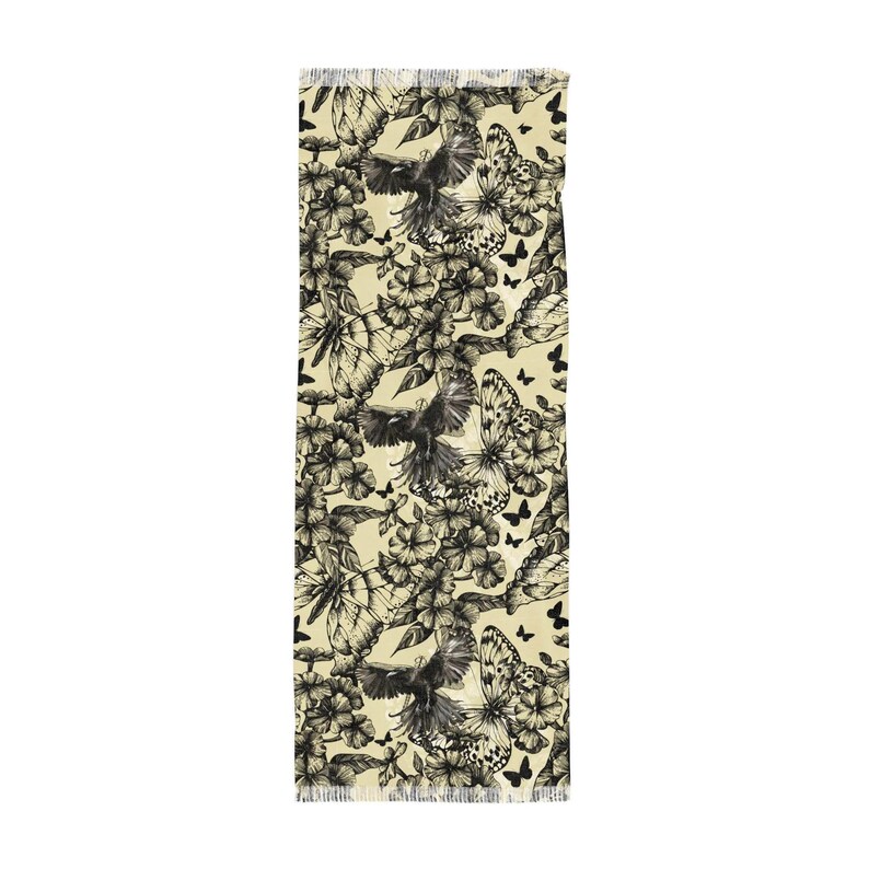 Peut inclure: Un chemin de table rectangulaire au fond cr&egrave;me, orn&eacute; d'un motif r&eacute;p&eacute;titif &agrave; l'encre noire repr&eacute;sentant des oiseaux en vol, des papillons d&eacute;taill&eacute;s et diverses fleurs. Les bords sont termin&eacute;s par une courte frange d&eacute;licate.