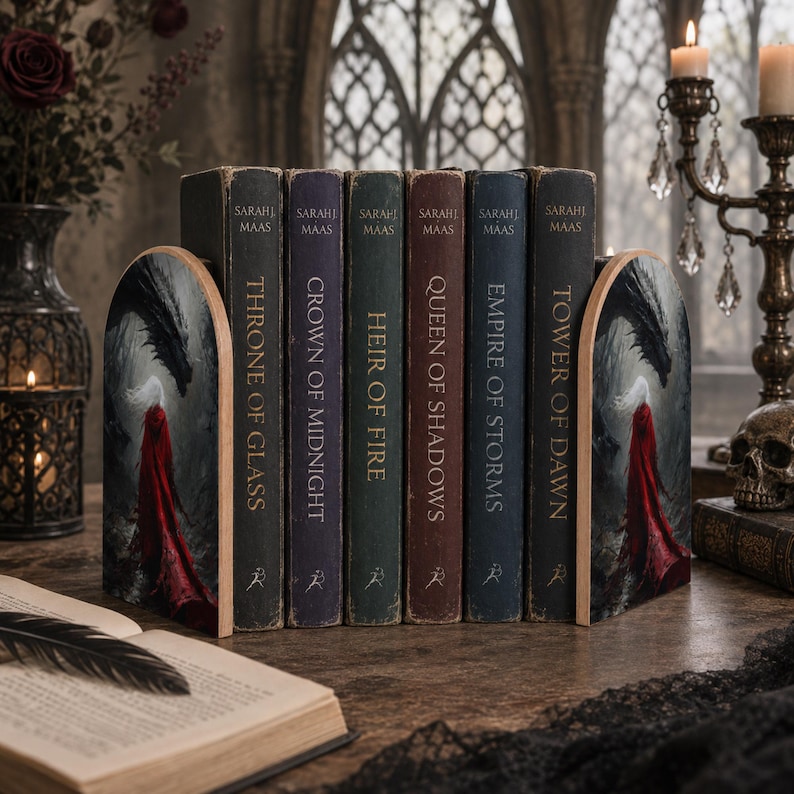 K&ouml;nnte beinhalten: Ein Set aus zwei gew&ouml;lbten Buchst&uuml;tzen aus Holz mit einer gedruckten Illustration einer Figur im roten Umhang, die einem Drachen gegen&uuml;bersteht, und sechs B&uuml;chern von Sarah J. Maas mit den Titeln Throne of Glass, Crown of Midnight, Heir of Fire, Queen of Shadows, Empire of Storms und Tower of Dawn.